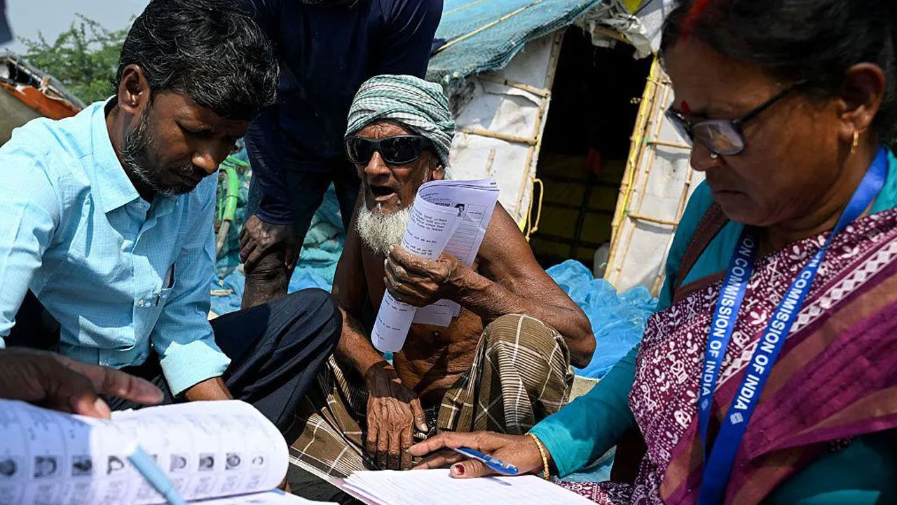 পশ্চিমবঙ্গে ভোটার তালিকা সংশোধনের সময় কর্মকর্তারা নিবন্ধন ফরম বিতরণ করছেন। ছবি: এএফপি