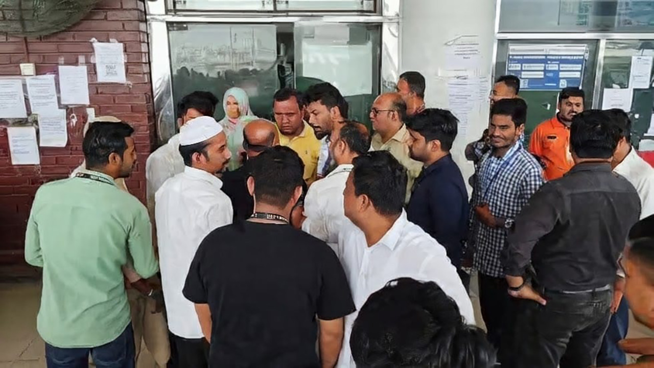 বিপাকে পড়া প্রবাসীদের ঘিরে ধরেছে হোটেলকর্মীরা। ছবি: চরচা